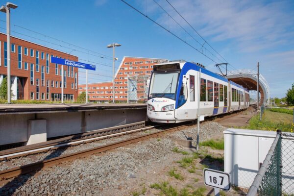 RandstadRail-tram arriveert op station Leidschenveen met moderne gebouwen op de achtergrond.